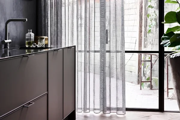 Grijze linnenlook vitrage in keuken - AC Mooi Wonen Culemborg Grijze vitrage in linnenlook in een keuken met stalen deur